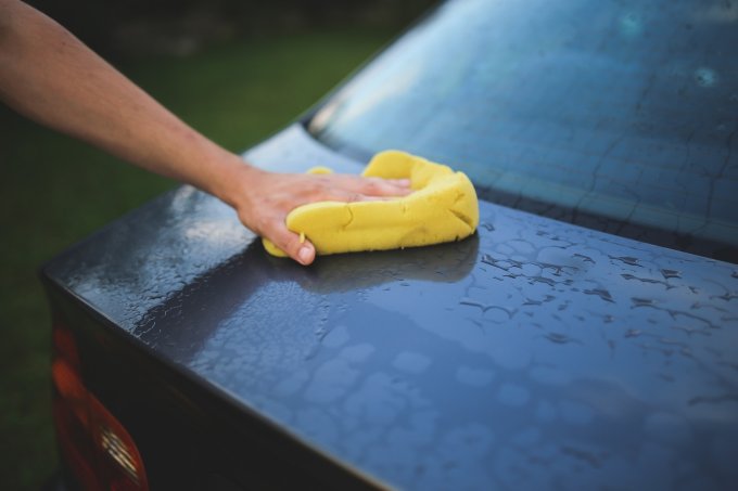 osoba myjąca samochód